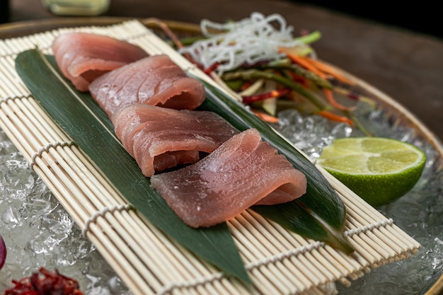 Sushi on green leaves on wooden with lemon vegatables background