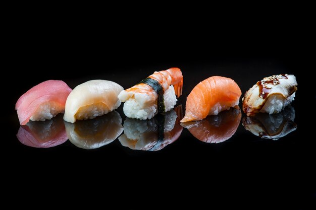 Sushi roll on a black background reflection  japanese food close up