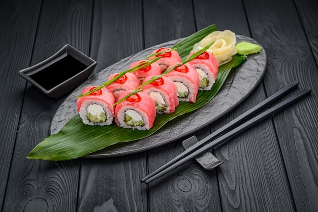 Sushi roll dragon with tuna Traditional delicious fresh sushi roll set on a black background Sushi menu Japanese kitchen restaurant Asian food