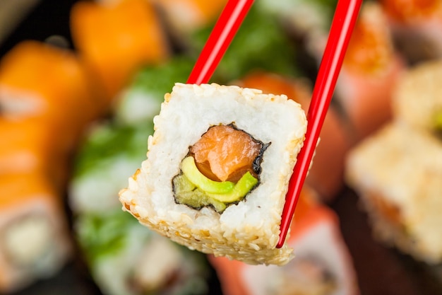 Sushi roll with chopsticks isolated on  background