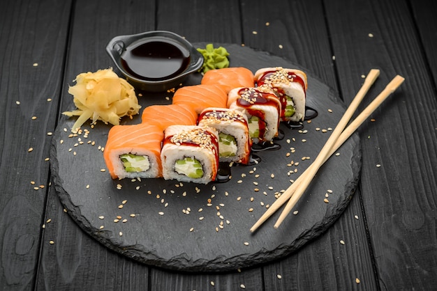 Sushi roll with eel and salmon on black