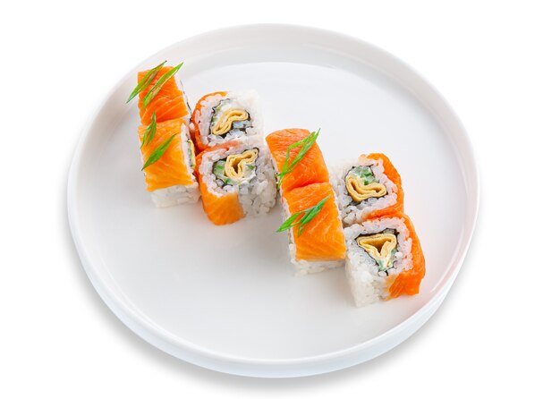 Sushi roll with salmon, omelet and vegetables. On a white ceramic plate. White background. Isolated.