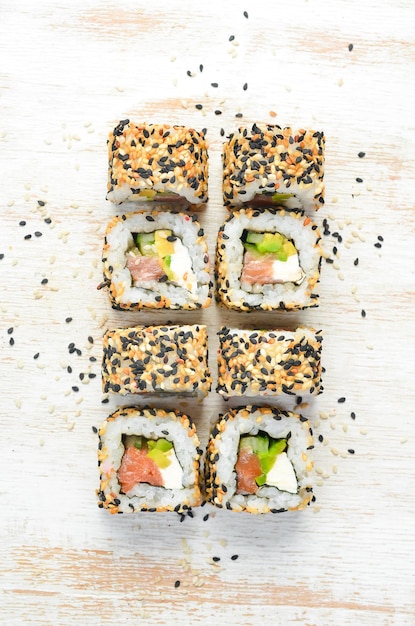 Sushi roll with sesame Philadelphia cheese salmon avocado Japanese Traditional Cuisine Top view Rustic style