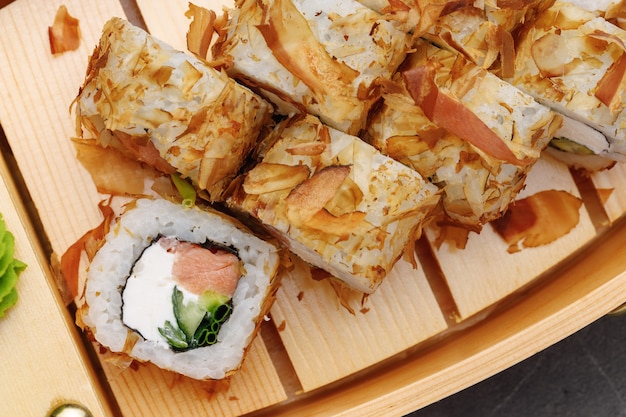 Sushi roll with tuna shavings on plate close up