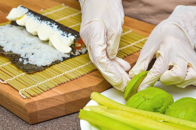 Sushi and rolls preparation process, top view, avocado for Japanese sushi.