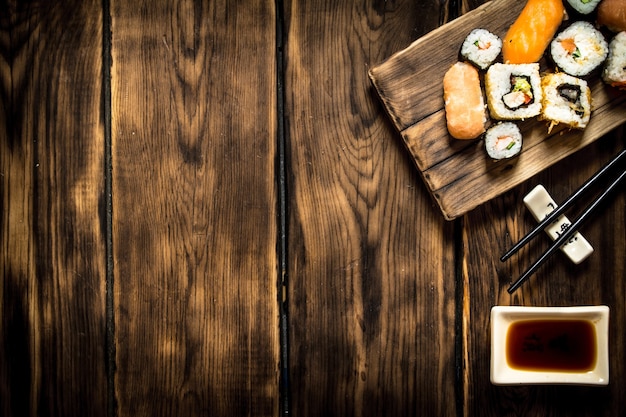 Sushi and rolls seafood with soy sauce. On wooden background.