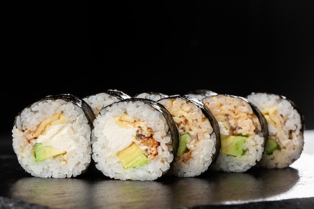 Sushi Rolls with eel, avocado, omelet and Cream Cheese inside.