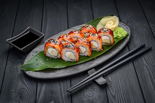 Sushi rolls with grilled salmon and mango Traditional delicious fresh sushi roll set on a black background Sushi menu Japanese kitchen restaurant Asian food