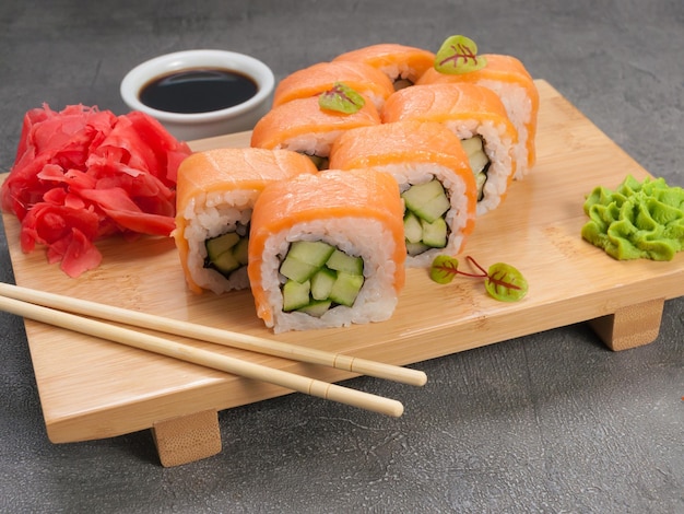 Sushi rolls with salmon and cucumber on a wooden board