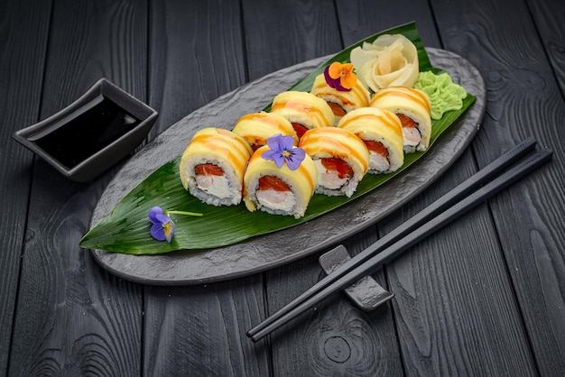 Sushi rolls with salmon shrimp and mango Traditional delicious fresh sushi roll set on a black background Sushi menu Japanese kitchen restaurant Asian food