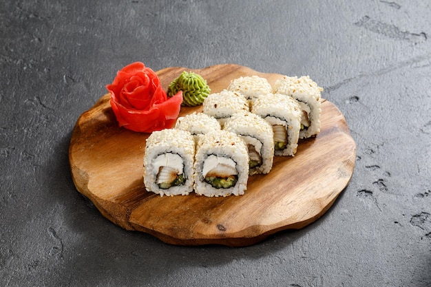 Sushi rolls on a wooden plate served with wasabi and Ginger