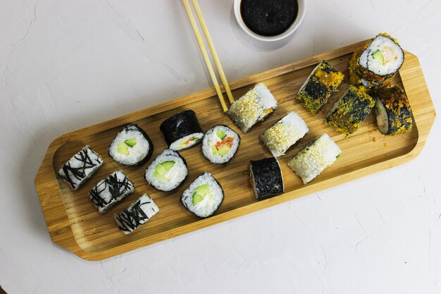 Sushi rolls on a wooden tray with soy sauce