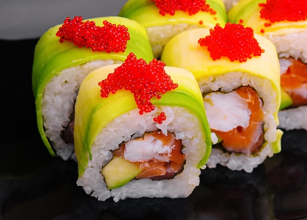 sushi rolls wrapped with avocado and shrimp inside