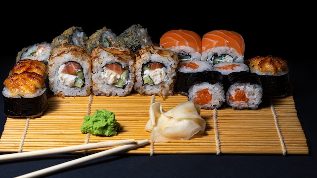 Sushi A set of sushi rolls on a bamboo serving mat with wasabi ginger and chopsticks