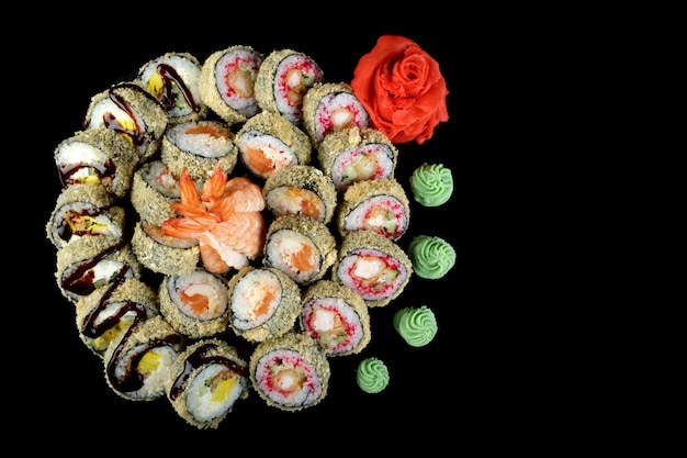 Sushi set of various sushi rolls on a black background