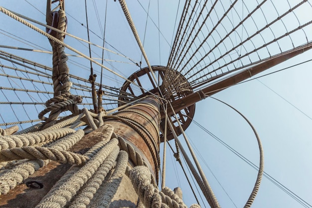 Suspension bridge on galleon with wood and rope against sky