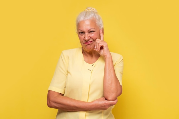 Suspicious elderly woman showing distrustful look at camera