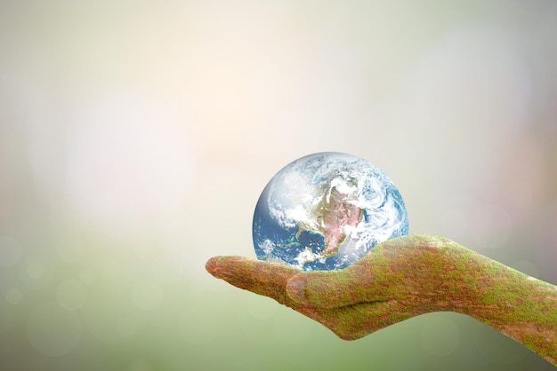 Sustain earth concept Human hands holding global over blurred blue nature background Elements of this image furnished by NASA