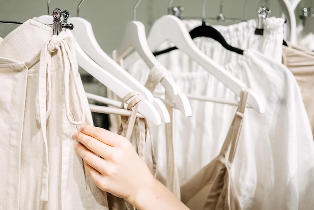 Sustainable fashion slow fashion close up shot of female hand taking clothing rack with natural