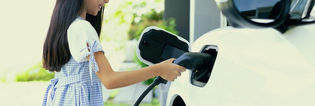 Sustainable power source for progressive lifestyle shown by a girl hold EV plug