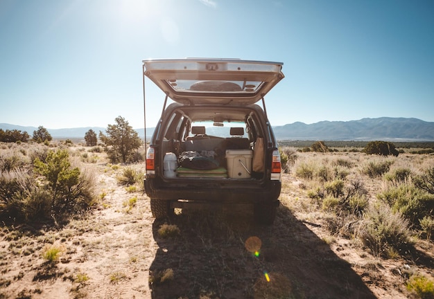 SUV parked in the outdoors with camping equipment in its trunk on a sunny day