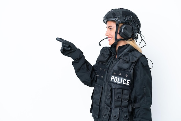 SWAT caucasian woman isolated on white background pointing finger to the side