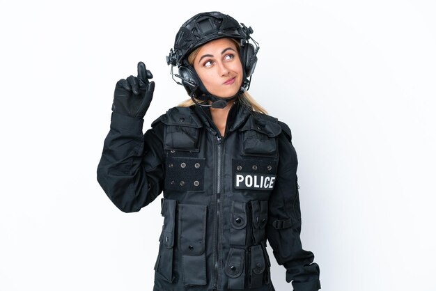 SWAT caucasian woman isolated on white background with fingers crossing and wishing the best