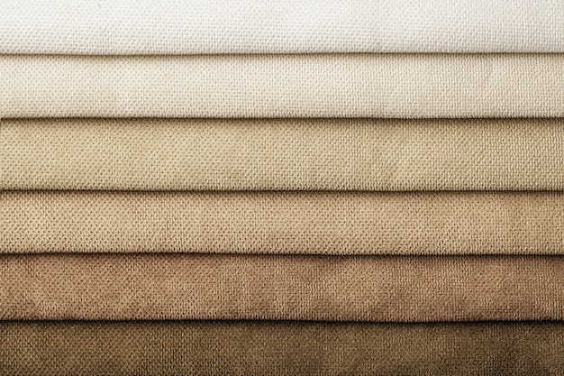 Swatch of woven textile shade and gradient of brown colors, background. Catalog and palette beige tone of Interior fabric for furniture, closeup. Collection of cloth with wicker pattern.