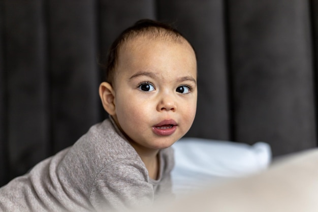 Sweet baby boy on the bed Just awake toddler Funny face of chubby child