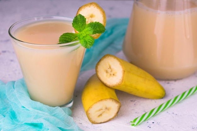 Sweet banana juice on a blue background Closeup