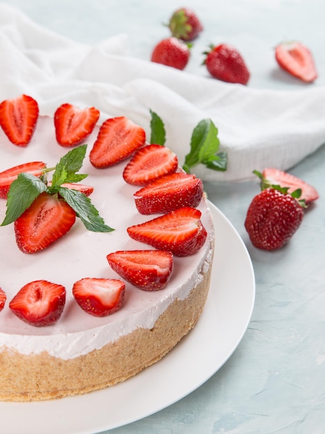 Sweet breakfast delicious cheesecake with fresh strawberries and mint homemade recipe without baking on a blue stone table Copy space