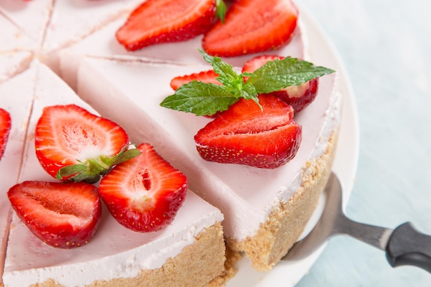 Sweet breakfast delicious cheesecake with fresh strawberries and mint homemade recipe without baking on a blue stone table Copy space