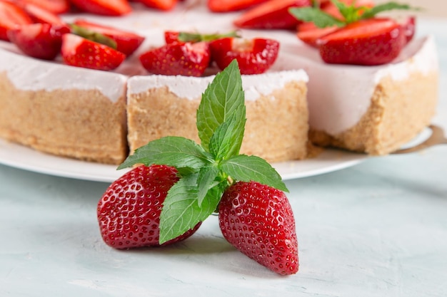 Sweet breakfast delicious cheesecake with fresh strawberries and mint homemade recipe without baking on a blue stone table Copy space