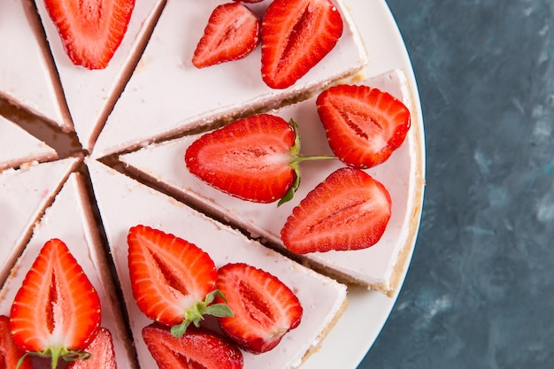 Sweet breakfast delicious cheesecake with fresh strawberries and mint homemade recipe without baking on a dark blue stone table Copy space