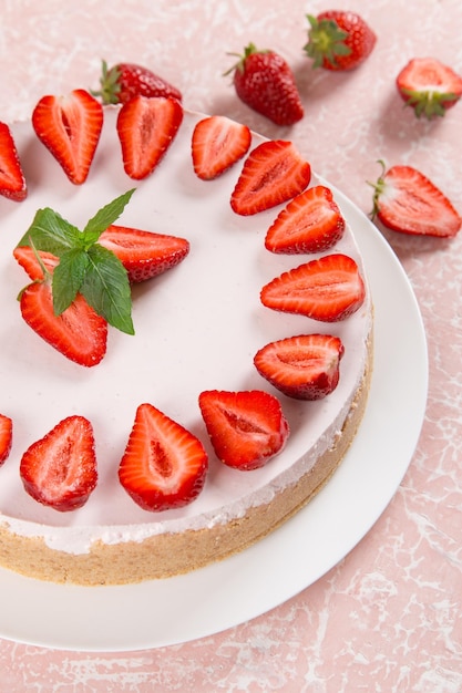 Sweet breakfast delicious cheesecake with fresh strawberries and mint homemade recipe without baking on a pink stone table Copy space