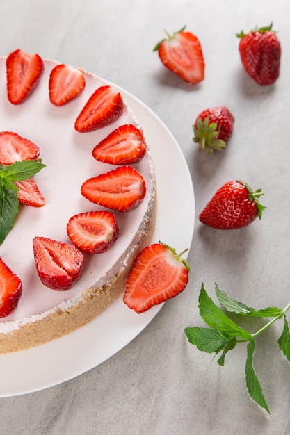 Sweet breakfast delicious cheesecake with fresh strawberries and mint homemade recipe without baking on a stone table Copy space