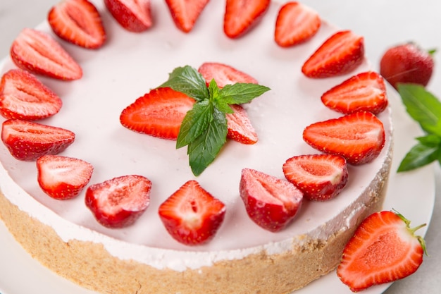 Sweet breakfast delicious cheesecake with fresh strawberries and mint homemade recipe without baking on a stone table Copy space