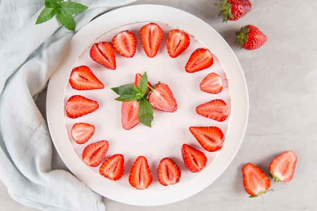 Sweet breakfast delicious cheesecake with fresh strawberries and mint homemade recipe without baking on a stone table Copy space