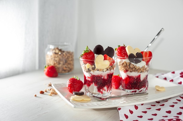 Sweet breakfast on valentines day on a white wooden table creamy dessert with ripe strawberries and