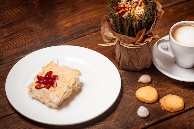 Sweet cake cup of latte on wooden table