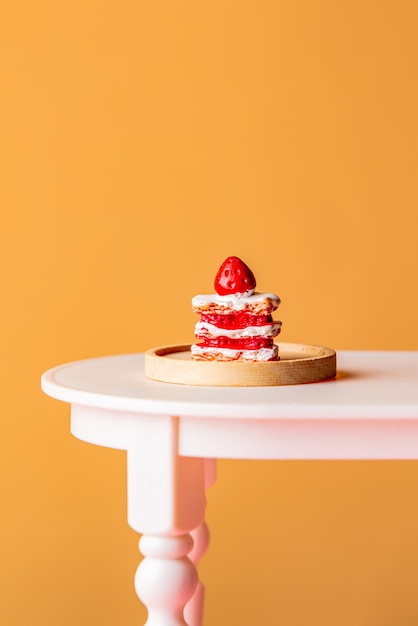 Photo sweet cake on a table on yellow background