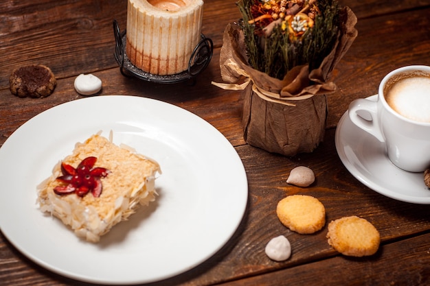 Sweet cake with cup of coffee on wooden table