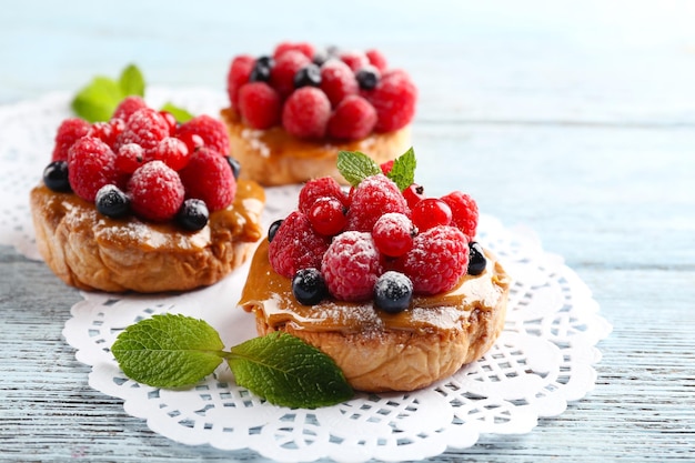 Sweet cakes with berries on table closeup