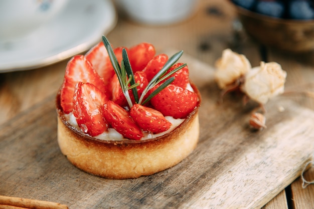 Sweet cakes with berries on a wooden table closeup Cake made of yeastfree dough