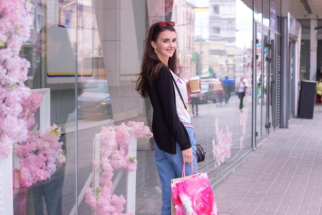 sweet charming lady near urban shops worth with packages and smiles