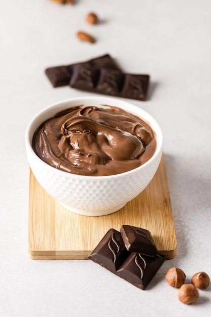 Sweet Chocolate and Nuts Cream in Bowl on Wooden Tray Gray Background Dessert Breakfast Vertical