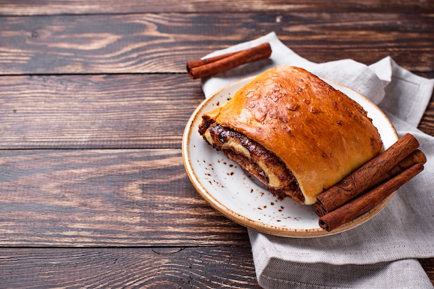 Sweet cinnamon bun on wooden table