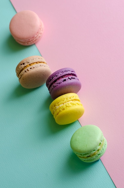 Sweet colorful macaroons on colorful pastel.