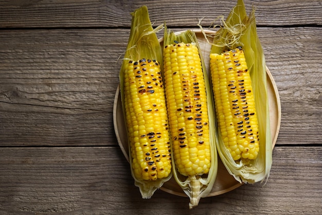 Sweet corn food sweet corn cooked on wooden plate background ripe corn cobs grilled sweetcorn for food vegan dinner or snack top view