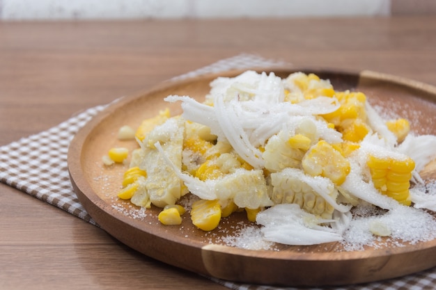 Sweet Corn with coconut and sugar on wooden plate